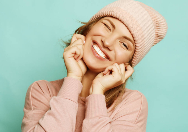 Image of happy young lady wearing pink hat and sweater - Fotó, kép
