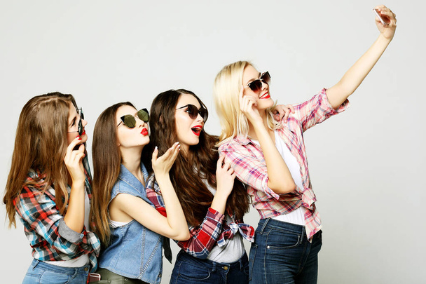 four happy teenage girls with smartphone taking selfie - Фото, изображение