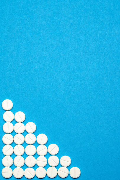 group of round white pills on blue background - Фото, изображение