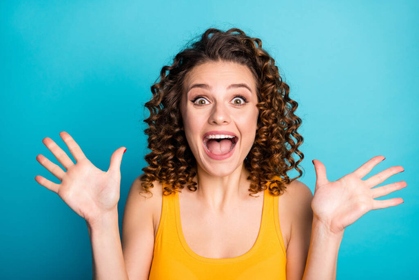 Photo of girlish foxy young lady excited look open mouth raise hands wear yellow singlet isolated blue color background - Φωτογραφία, εικόνα