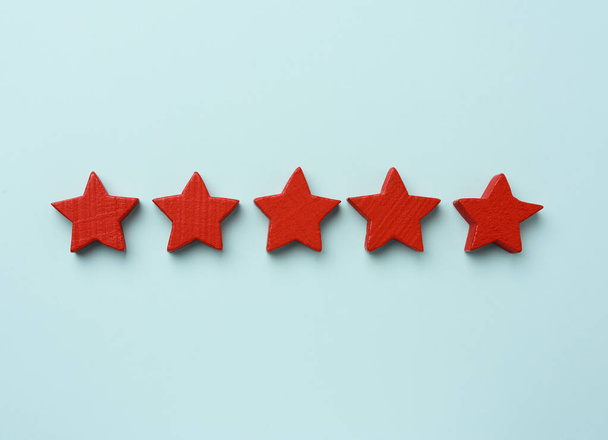 five red wooden stars on a blue background, high score, rating - Φωτογραφία, εικόνα