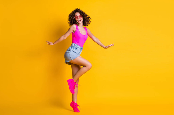 Full length body size view of her she nice-looking attractive lovely cheerful wavy-haired girl jumping having fun dancing disco party isolated on bright vivid shine vibrant yellow color background - Foto, Imagem