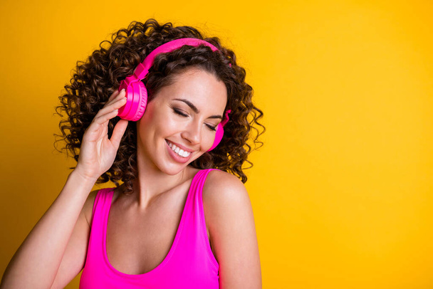 Closeup photo of attractive cute lady wavy hairdo listen earphones hit fm popular song overjoyed dreamy eyes closed wear pink tank top singlet isolated vibrant shine yellow color background - Fotoğraf, Görsel