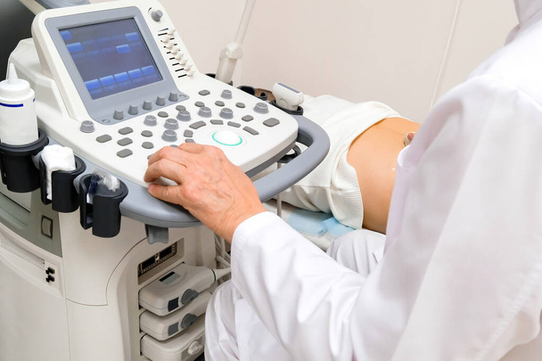 Doktor siedzi przy ultrasonografie. Aparatura diagnostyczna - Zdjęcie, obraz