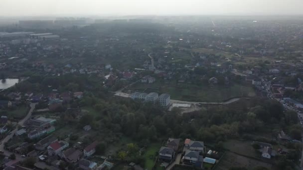 Sofiyevskaya Borshchagovka, regio Kiev, Oekraïne - november 2020: Uitzicht vanuit de lucht op huisjes en appartementengebouwen. Meer tussen particuliere huizen. Luchtfoto van huisjes in de buurt van de stad. - Video