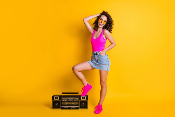 Full length photo of funny wavy hipster dj lady stand leg boom box event holiday beach pool party wear sun specs pink singlet denim skirt shoes isolated shine vivid yellow color background - Foto, Bild
