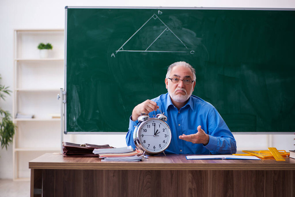 Oude mannelijke wiskundeleraar in tijdmanagementconcept - Foto, afbeelding