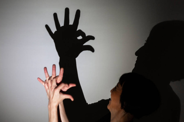 грати тінь, спроектована на білому екрані. руки людини сприяють обробці півня або курки
 - Фото, зображення