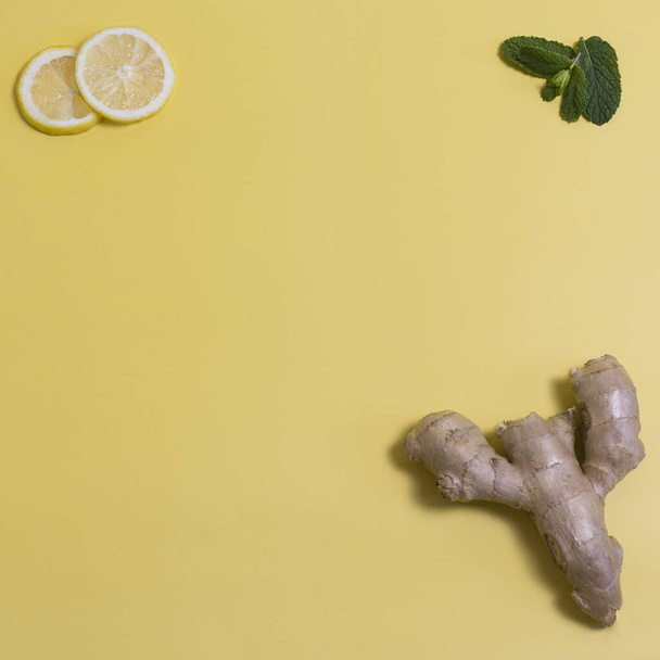 ginger with lemon slices and mint on a yellow background - Foto, Bild