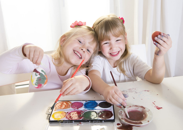 heureux blonded filles peinture un Pâques oeufs blanc fenêtre
  - Photo, image