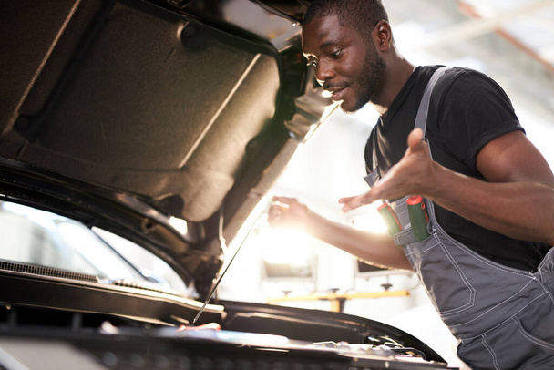 černý africký automechanik nechápe, jak řešit problémy se strojem - Fotografie, Obrázek