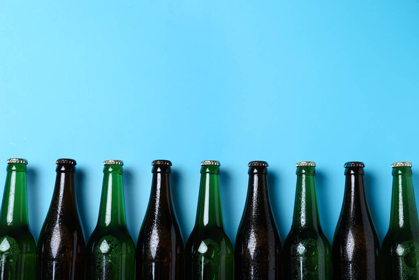 ライトブルーの背景にビールのボトル、フラットレイアウト。テキストのスペース - 写真・画像