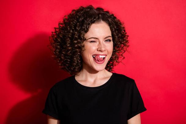 Photo of nice young people wink flirt bite tongue out seductive isolated on bright red color background - Fotoğraf, Görsel