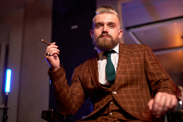 portrait of handsome adult man in a formal costume smoking a cigar - Фото, зображення