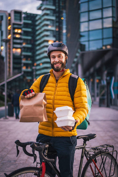 Food delivery service, rider delivering food to clints with bicycle - Concepts about transportation, food delivery and technology - Фото, изображение