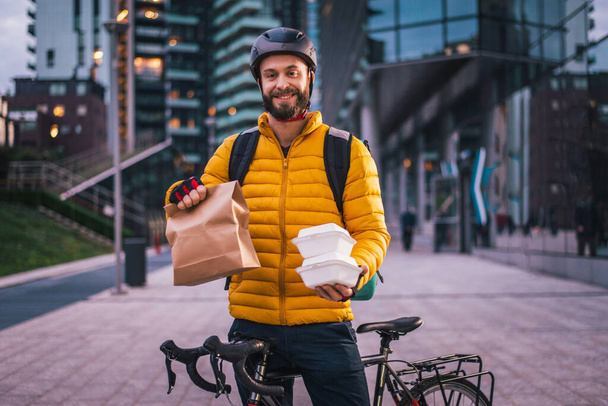 Food delivery service, rider delivering food to clints with bicycle - Concepts about transportation, food delivery and technology - Zdjęcie, obraz
