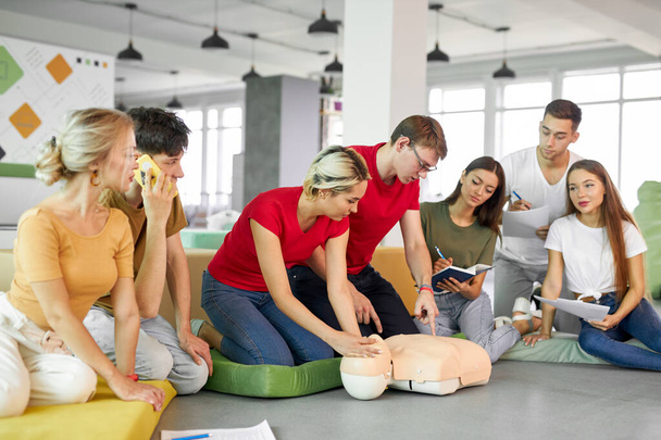 CPR class with caucasian instructors speaking and demonstrating help first aid - Foto, immagini