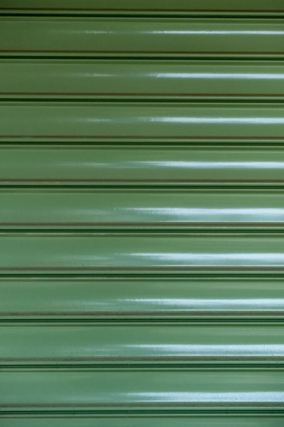 Metalli rulla suljin rakenne tausta, vihreä väri. Kaupan sisäänkäynti suljettu, turvallisuus - Valokuva, kuva