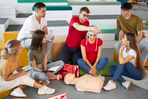 young confident male safety instructor teach students to bandage the head - Φωτογραφία, εικόνα