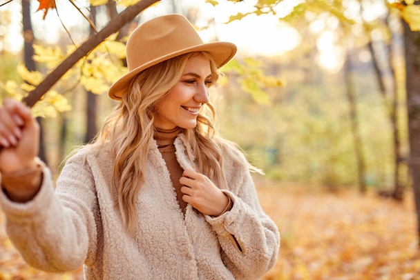 fashionable pretty woman walking outdoors in autumn spring park - Foto, Imagen