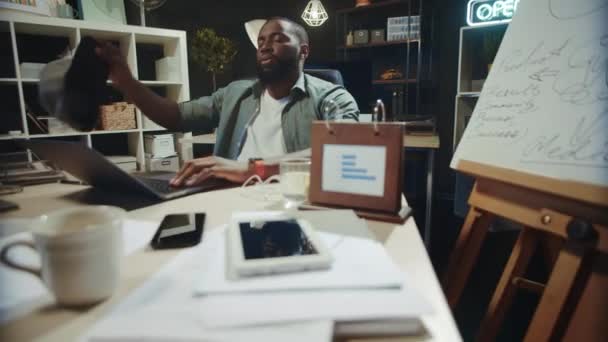 Uupunut afrikkalainen amerikkalainen liikemies, joka rentoutuu toimistotuolissa sisätiloissa. - Materiaali, video