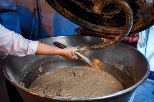 Lifestyle reportaasi valokuvaus piirakka ja leivonnaiset tukku leipomo tehdas työntekijä tekee leivonnaiset taikina jättiläinen mikseri - Valokuva, kuva