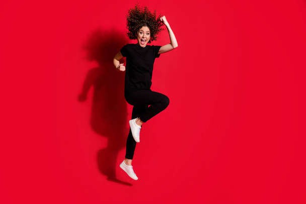Photo portrait full body view of cheerful woman jumping up isolated on vivid red colored background - Φωτογραφία, εικόνα