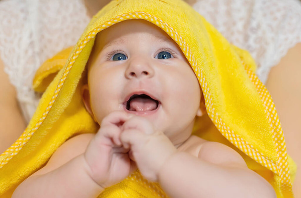 Baby na het baden in een handdoek. Selectieve focus. Mensen. - Foto, afbeelding