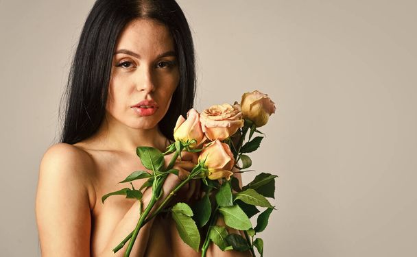Spa treatments for skin rejuvenation. sexy naked woman hold rose flower. soft and tender. healthy woman hold rose with petals. sexy nude beautiful woman in flowers. love and romance. copy space - Photo, Image