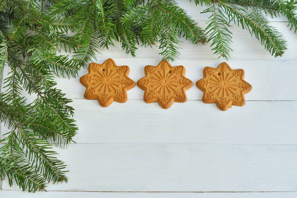 Christmas sweet composition. homemade gingerbread surrounded by fir branches, waiting for the new year. New Year card template. copy space, soft focus - Foto, immagini