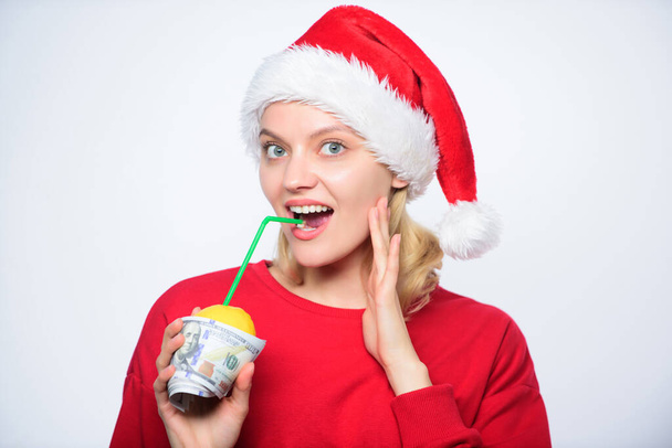 Totally natural lemon juice. Fresh lemonade drink with straw. Symbol of wealth and richness. Girl with lemon and money. Lemon money concept. Girl santa hat drink juice lemon wrapped in banknote - Photo, image