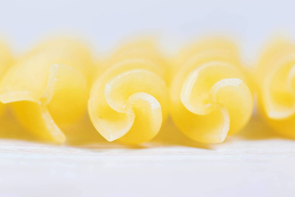 Abstract Closeup view of raw pasta on wooden background. - Photo, Image