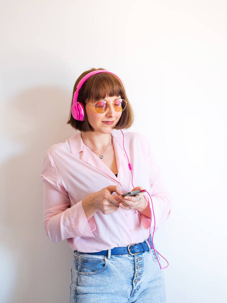 Mladá žena pomocí smartphonu se sluchátky - Fotografie, Obrázek