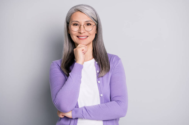 Portrait photo of smart elder intelligent female professor in the university wearing eyeglasses smiling touching face isolated on grey color background - Photo, image