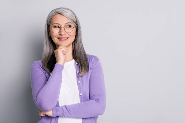 Portrait photo of smart elder intelligent business woman wearing eyeglasses looking at side thinking about idea touching face smiling isolated on grey color background - Foto, immagini