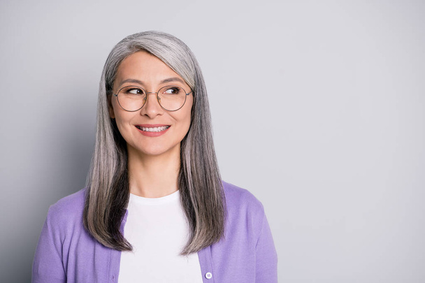 Portrait photo of satisfied smiling senior businesswoman wearing eyeglasses and purple cardigan dreaming planning isolated on grey color background - Φωτογραφία, εικόνα