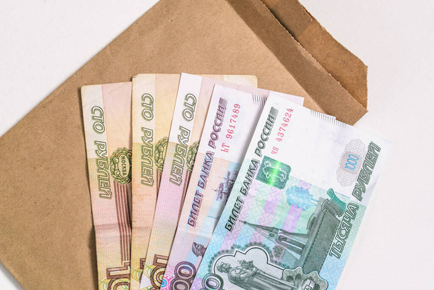 Російські гроші і картонний конверт. Банкноти ізольовані на білому. Верхній вид, плоский. - Фото, зображення