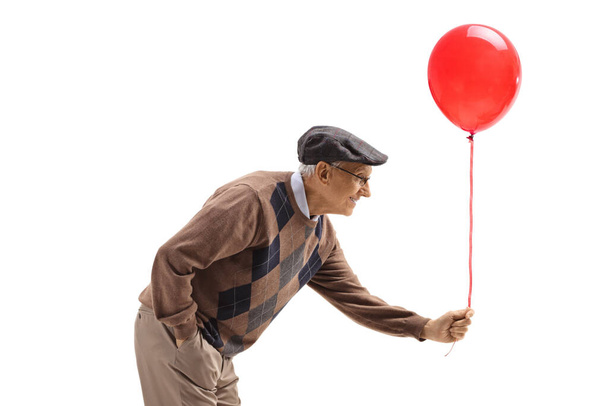 Elderly man handing a red balloon isolated on white background - Foto, Imagen
