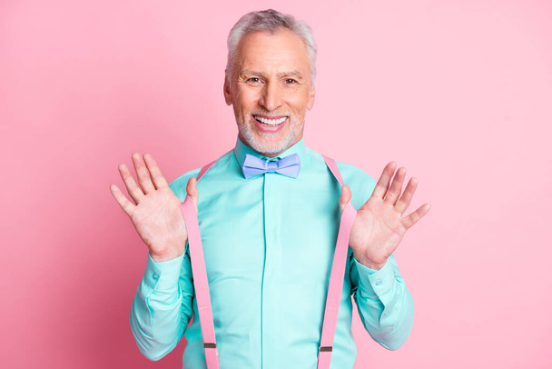 Photo portrait of smiling metrosexual with white beard keeping suspenders wearing shirt bowtie isolated on pink color background - Foto, Imagen