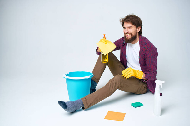 férfi a padlón egy kék vödör házi feladatot életmód profi - Fotó, kép