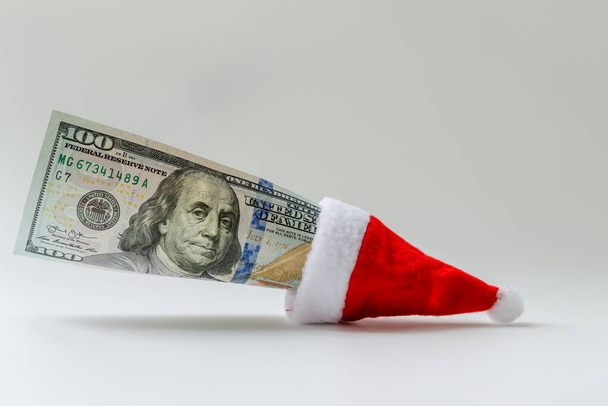 A hundred-dollar bill with the image of President Franklin is inserted in the Santa Claus hat. Free space for copying - Photo, Image
