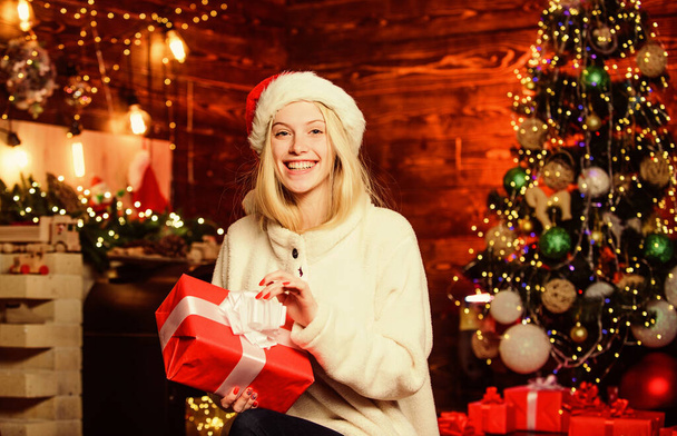 celebrate new year at home. xmas holiday gift. Decorate christmas tree. last preparation. Christmas time. cheerful girl red santa hat. happy woman love presents. Winter shopping sales - 写真・画像