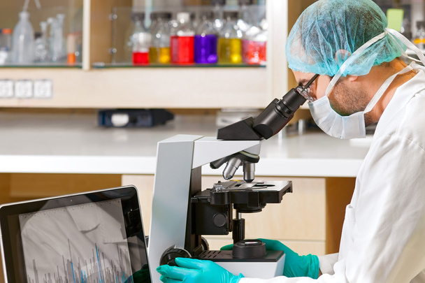 Scientist using a computer and microscope.  - Foto, Imagem