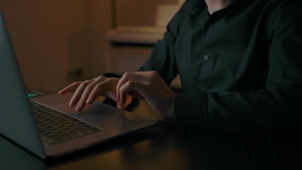 Een man werkt op een laptop in het interieur. - Video
