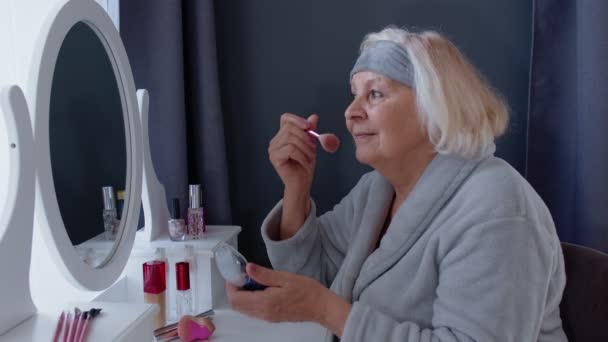 Oude senior vrouw grootmoeder verzorgen van de huid, aanbrengen van anti-rimpel foundation poeder met borstel - Video