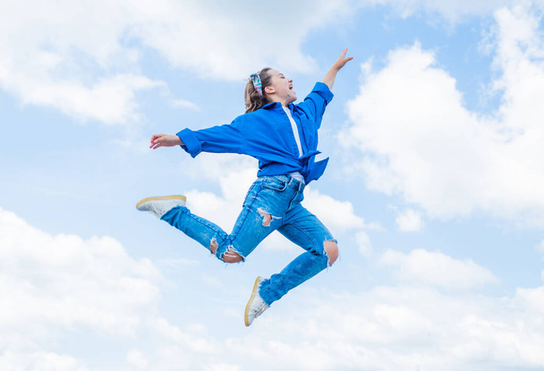 teen girl wearing casual fashion clothes jumping high on sky background, energy - Fotoğraf, Görsel