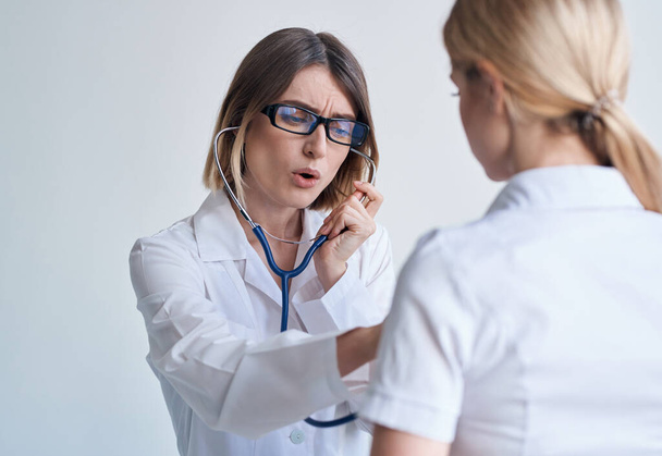 médico mulher profissional em vestido médico e óculos paciente estetoscópio azul - Foto, Imagem
