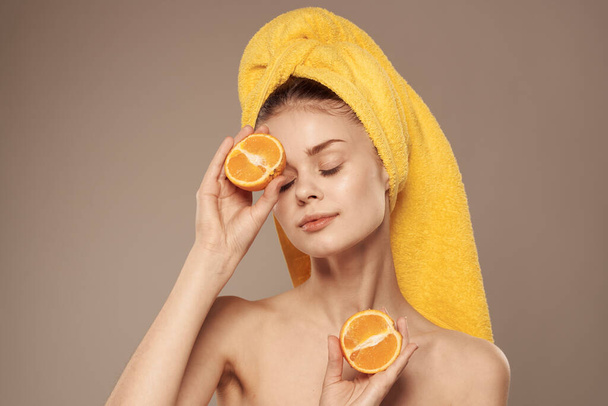 cheerful woman holding oranges near her eyes skin care - Foto, imagen