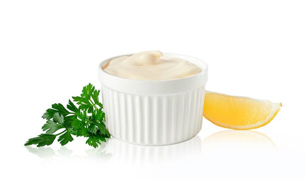 Tazón de mayonesa con limón y perejil aislado en blanco con camino de recorte. Elemento de diseño para la etiqueta del producto - Foto, imagen