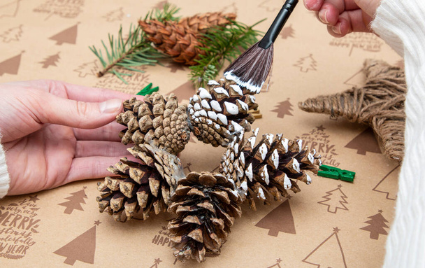 Gwiazda DIY z szyszkami sosnowymi na tle świątecznym, ręcznie robiona - Zdjęcie, obraz